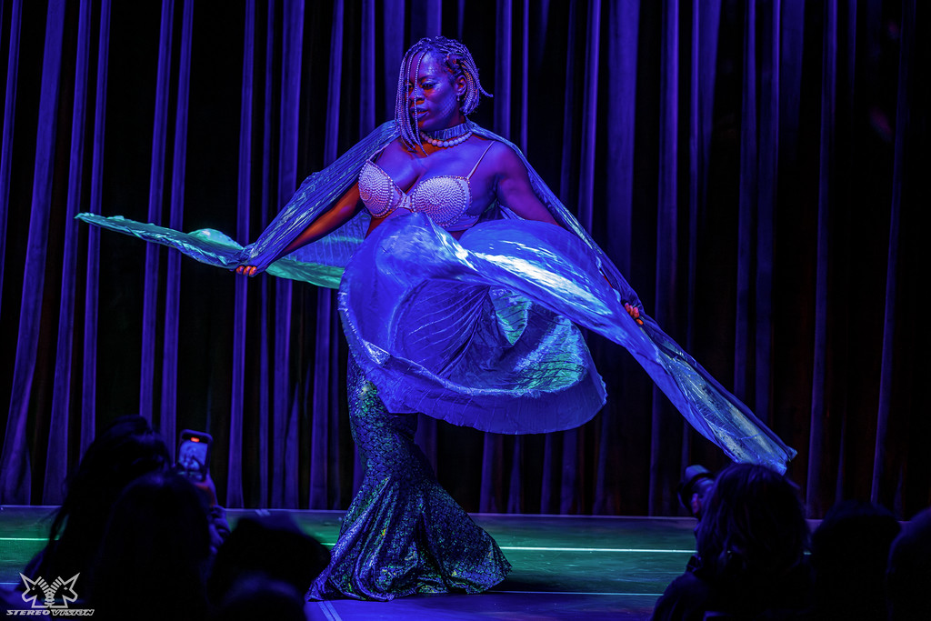 Bunny Vicious onstage in purple light, twirling her fabulous sparkling dress.