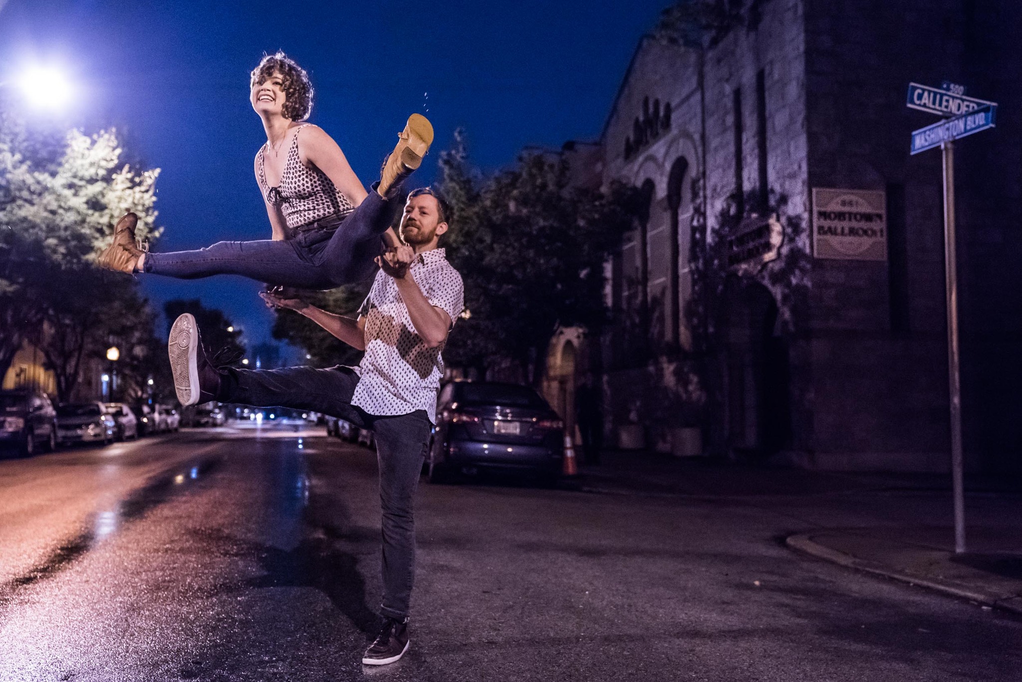 Charlie Wieprecht swinging his dance partner up into the air on a rainy street.